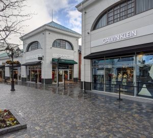 A photo of the West Midlands Designer Outlet featuring its architectural style, with the Calvin Klein shop in primary focus